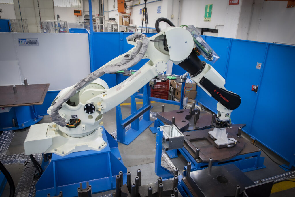 Braço robótico de manipulação de peças recolhendo uma peça de uma mesa de trabalho